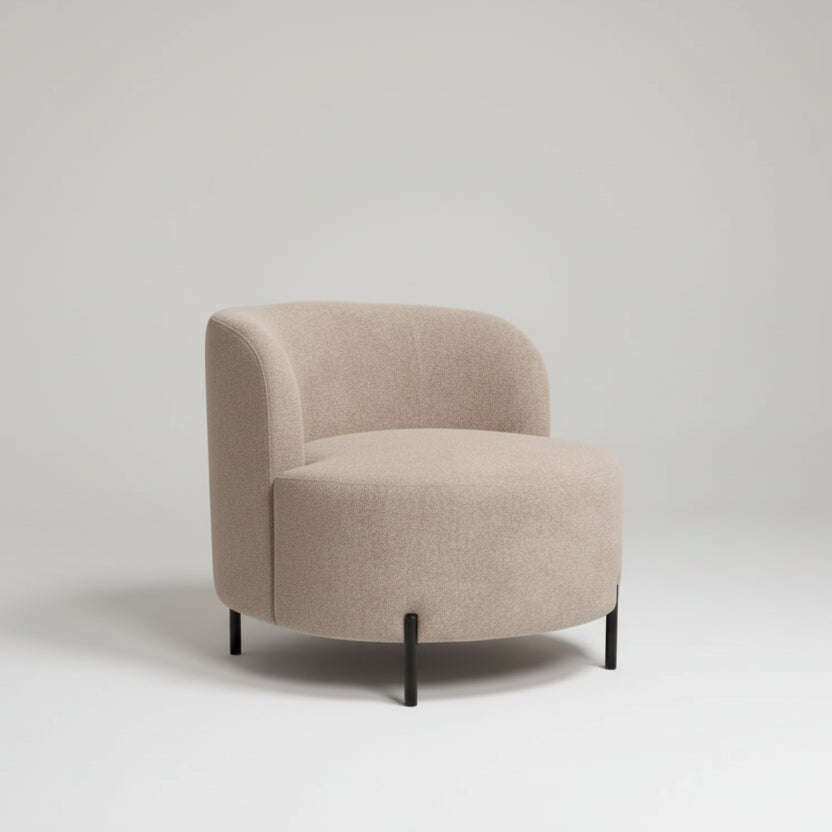 Beige armchair in a room with a small table, cup, and book