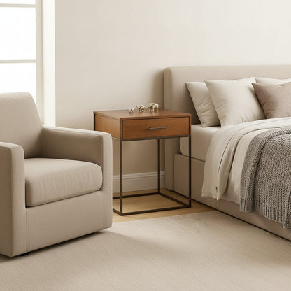 Wooden side table with metal frame next to a beige armchair in a room.