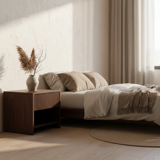Wooden nightstand with a lamp next to a bed in a bedroom setting